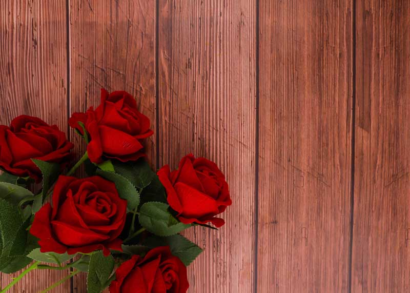 دانلود عکس دسته گل رز قرمز روی پس زمینه چوبی