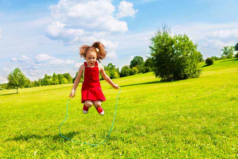 دانلود تصویر با کیفیت دختر بچه در حال طناب زدن در طبیعت
