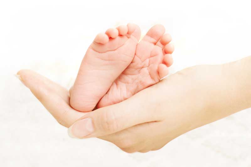 دانلود تصویر باکیفیت پای کوچک و زیبای نوزاد در دست مادر